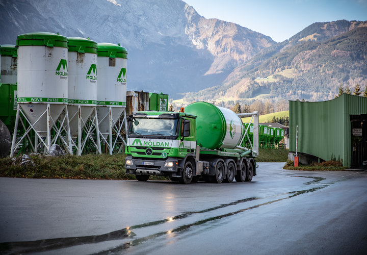 Ein fahernder Silosteller. Im Hintergrund sind Silos und Berge.