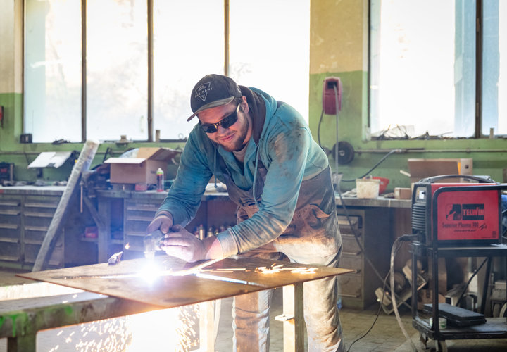 Ein Mitarbeiter der Schlosserei beim Schweißen einer Metallpaltte.