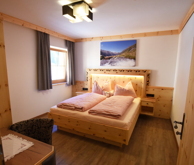 schönes Zimmer mit Bett im Krimmler Tauernhaus